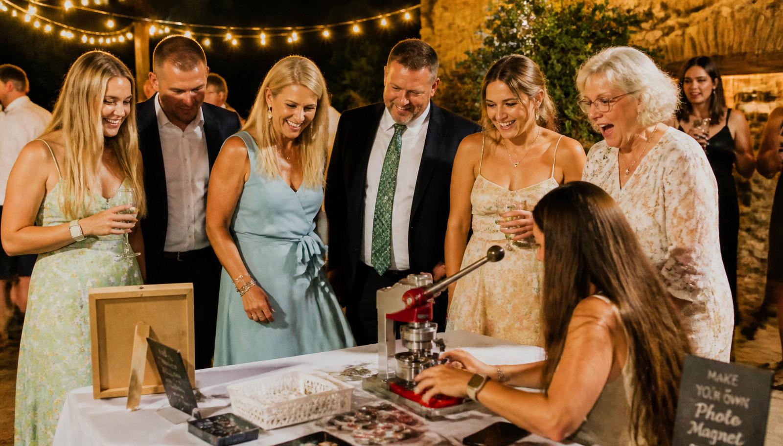 Snapped Memory Magnets booth pressing custom photo magnets at an evening wedding reception